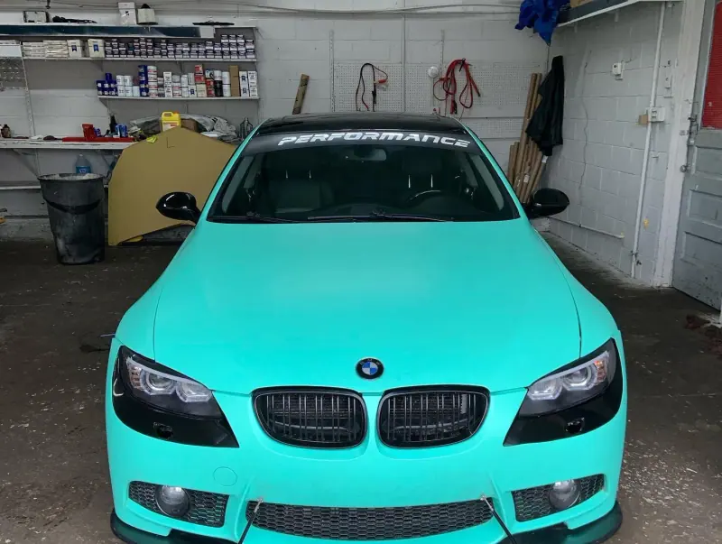 Mint green BMW 3 series, front view inside the shop