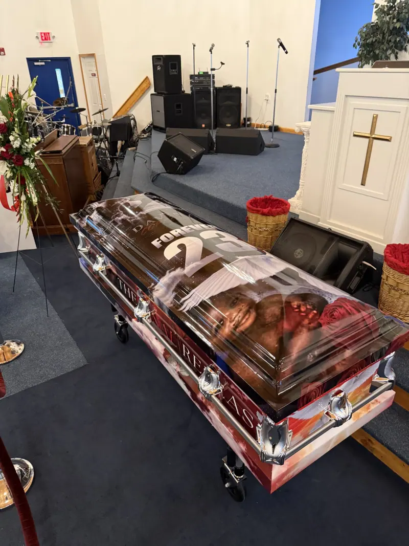 Casket in a custom printed memorial wrap at the front of a chapel