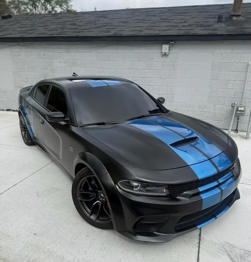 Matte black Dodge Charger with blue stripes, front three quarter view