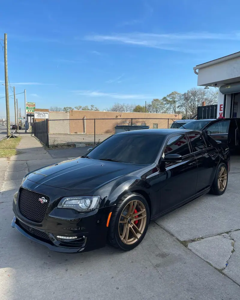 Black Chrysler 300 with bronze wheels, front three quarter view