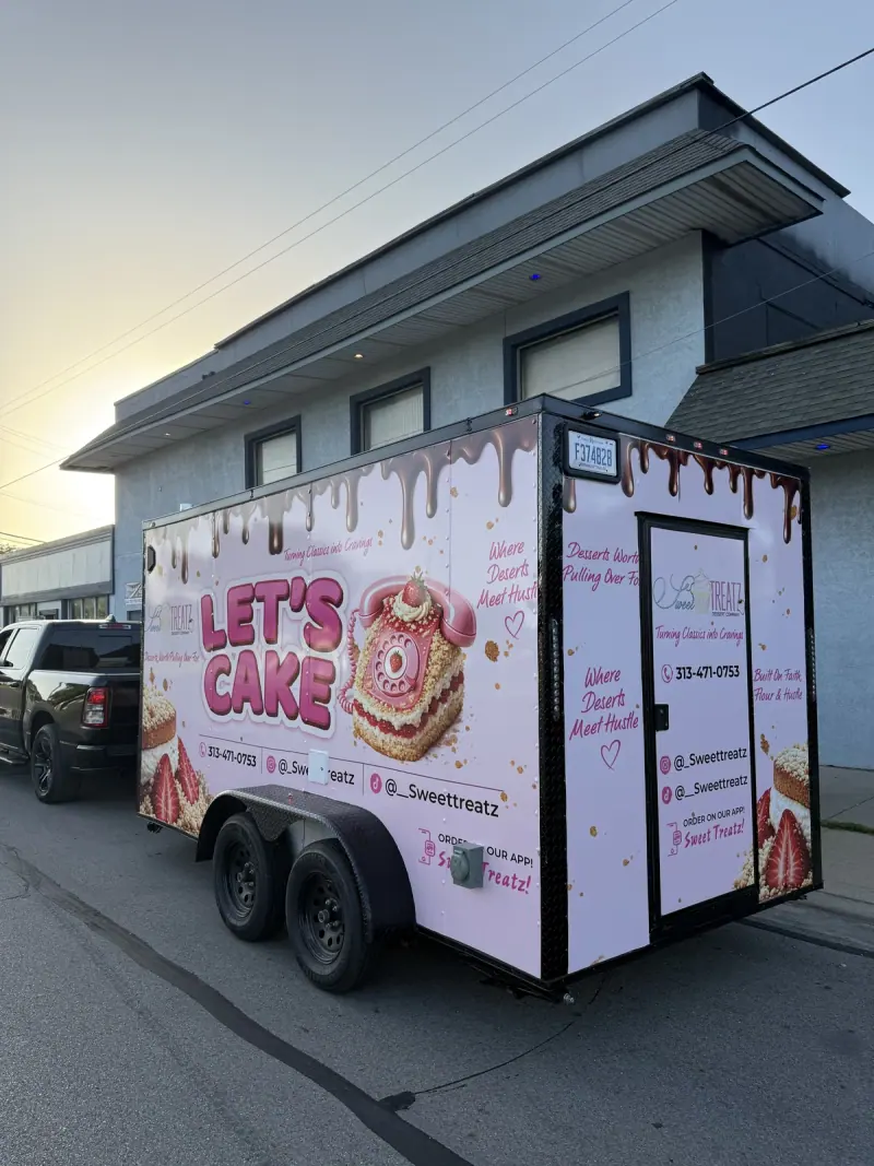 Enclosed trailer in a pink printed dessert wrap, front three quarter view