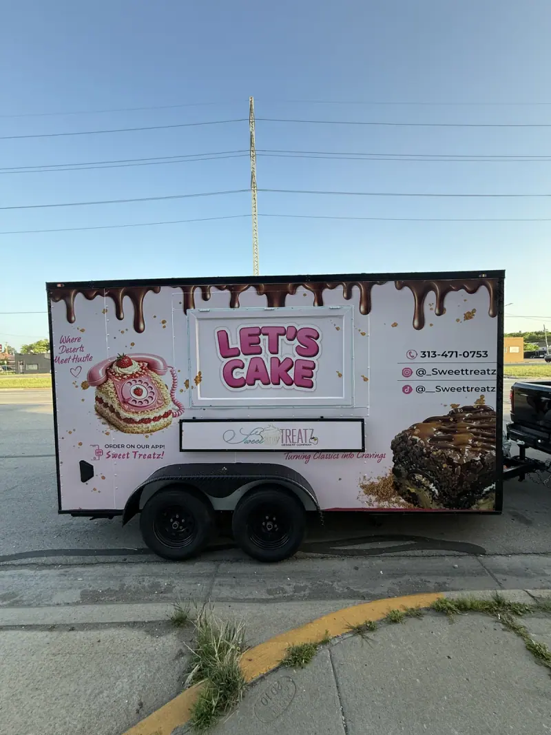 Enclosed trailer in a pink printed dessert wrap, side view