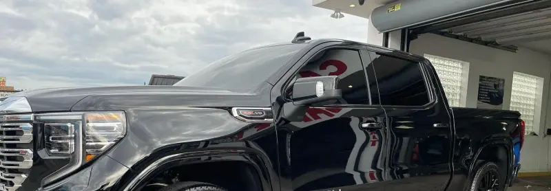 Gloss black GMC Denali pickup, wide crop