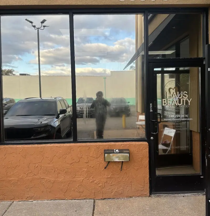 Salon storefront windows after window film, reflecting the sky