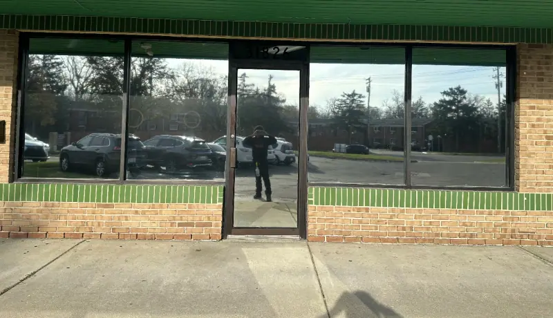 Storefront windows after window film, reflecting the parking lot