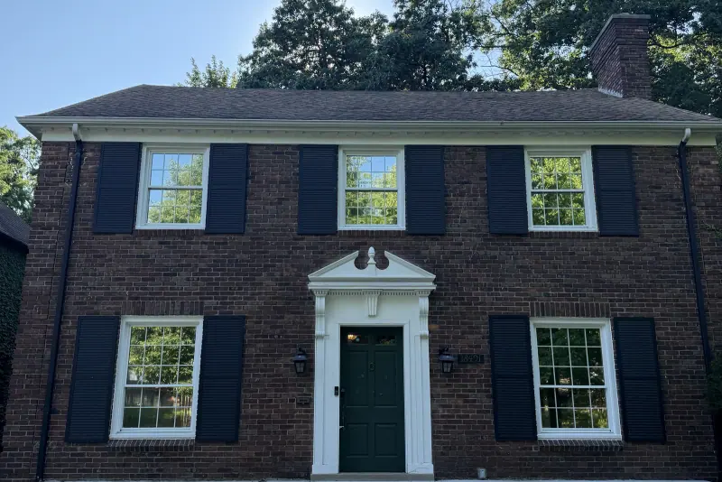 Two story brick home with window film on the front windows