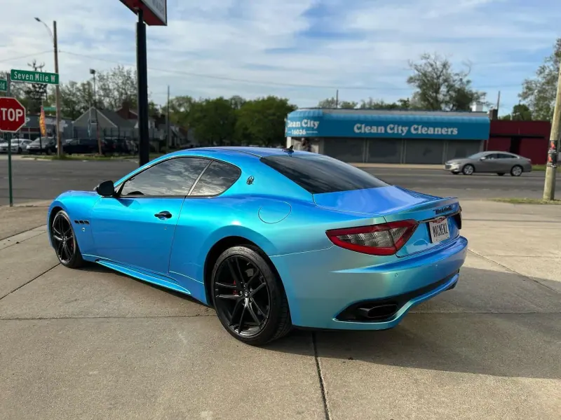 Light blue Maserati GranTurismo, rear three quarter view on the street