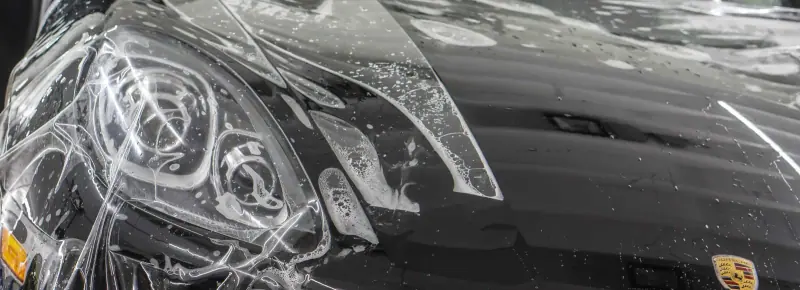 Paint protection film being laid over a headlight, close up