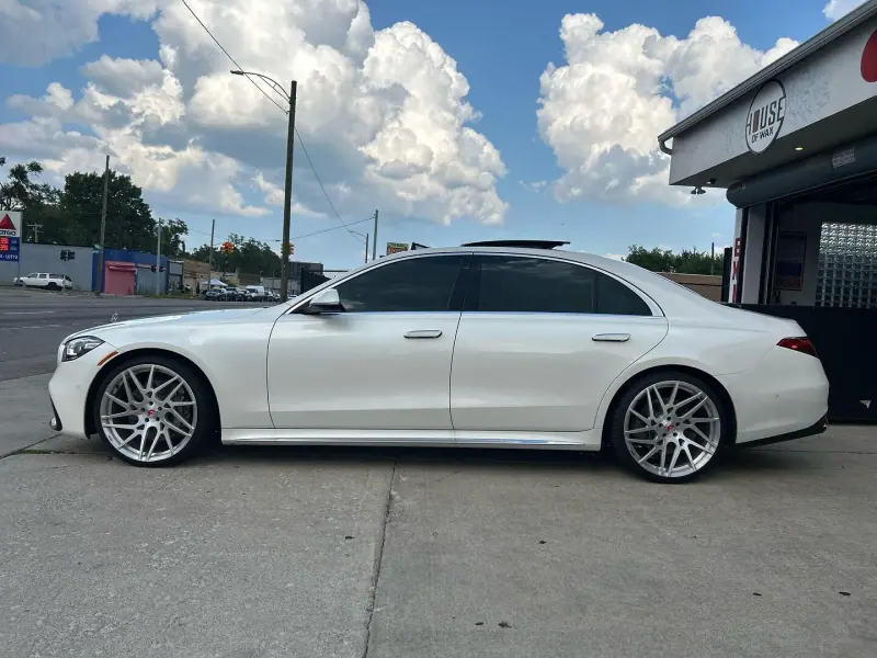 White Mercedes S class, side view under a cloudy sky