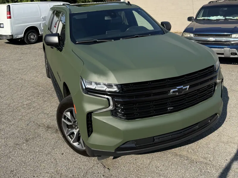 Matte green Chevy Suburban, front three quarter view