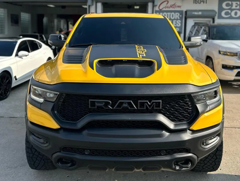 Yellow Ram TRX with a black hood, front view
