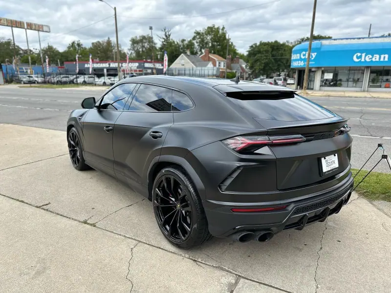 Satin black Lamborghini Urus, rear view on the street